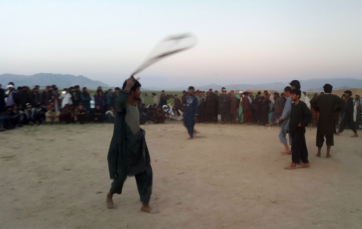 In this photograph taken on April 29, 2016, Afghan poppy farmers celebrate a bumper harvest with the traditional rope game of Dora in Naqil village in the Tarinkot district of Uruzgan province.
