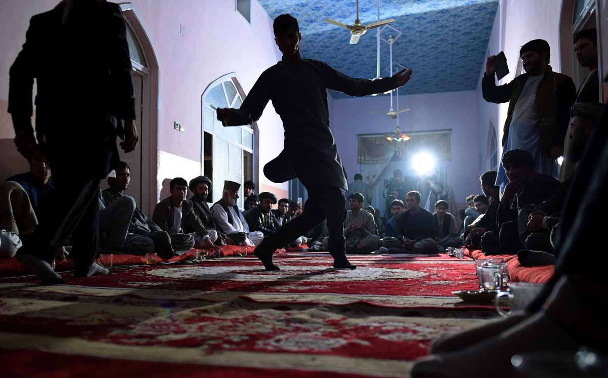 In this photograph taken on October 18, 2015, Afghan men dance in a wedding ceremony inside a house at Khoja Paytakht in Maimana, the capital of the northern province of Faryab.