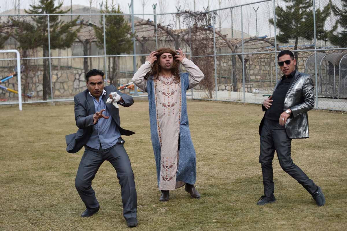 In this photograph taken on March 6, 2017, Afghan comedian Ibrahim Abed (L), Gholam Nabi Roashan (R) and Ahmad Siar Matin (C) perform a song while filming the comedy television show Shabak-e-Khanda on the outskirts of Kabul.