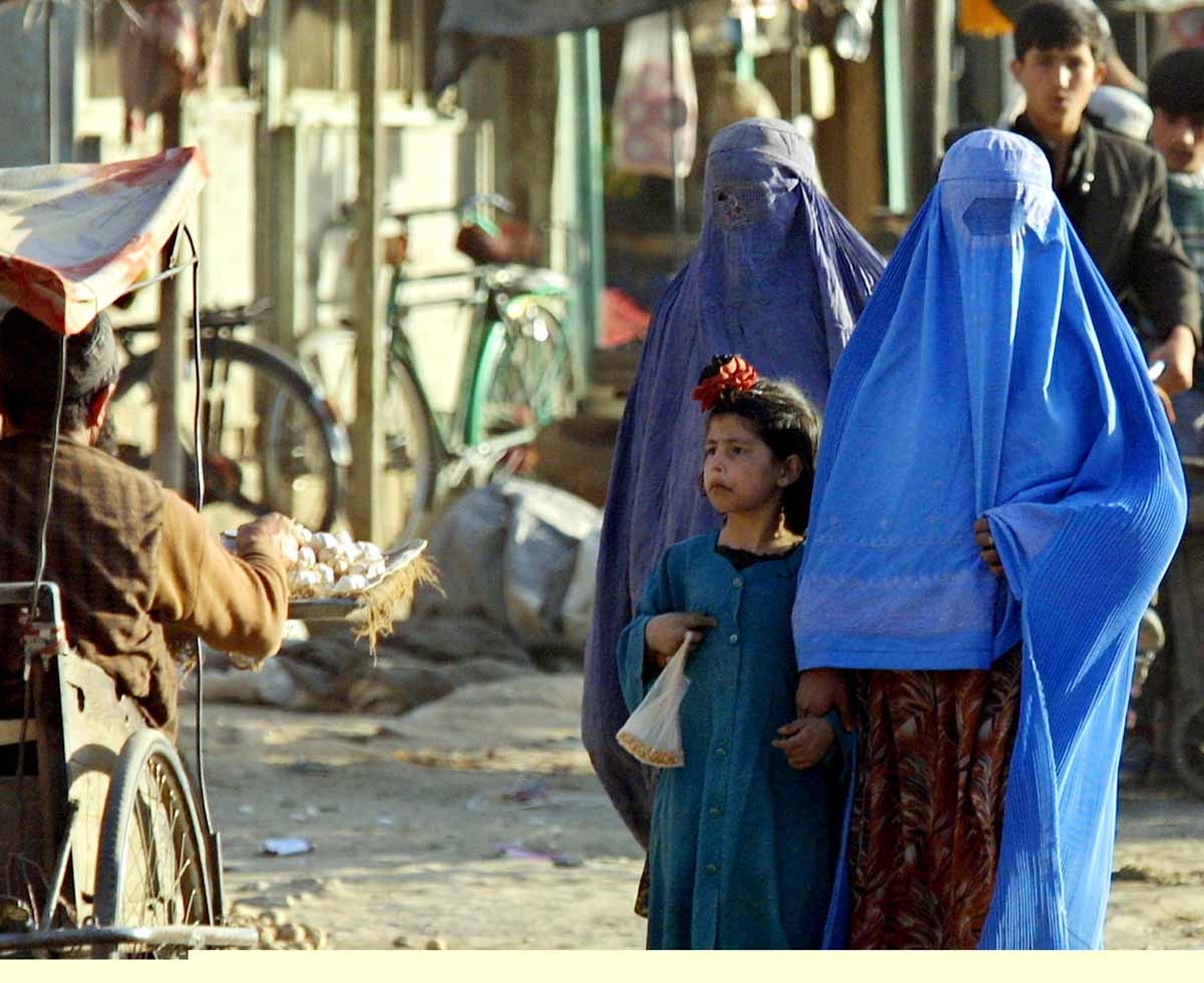 Afghani women walk in Kabul, 14 November 2001. It was forbidden for women to appear outdoors without close male relatives just a few days ago, before the capture of the city by the Northern Alliance forces 13 November.