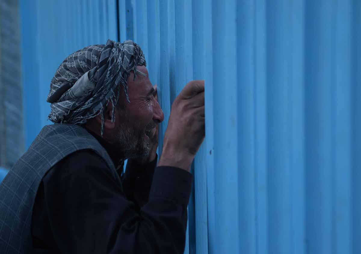 An Afghan man who lost his father in a gunmen attack weeps at the main gate of the Karte Sakhi shrine in Kabul on October 12, 2016.