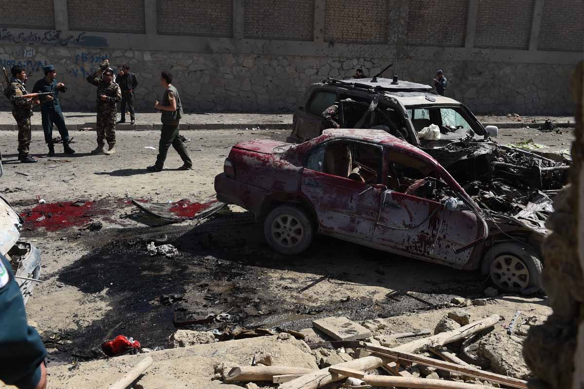 Afghan and foreign security forces inspect the site of a suicide attack in Kabul on May 17, 2015.