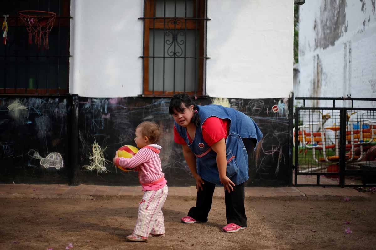 Noelia Garella, a kindergarten teacher born with Down Syndrome, plays with one year old child at the Jeromito kindergarten. Cordoba, Argentina on September 29, 2016. Noelia Garella, a kindergarten teacher born with Down Syndrome, plays with one year old child at the Jeromito kindergarten. Cordoba, Argentina on September 29, 2016.