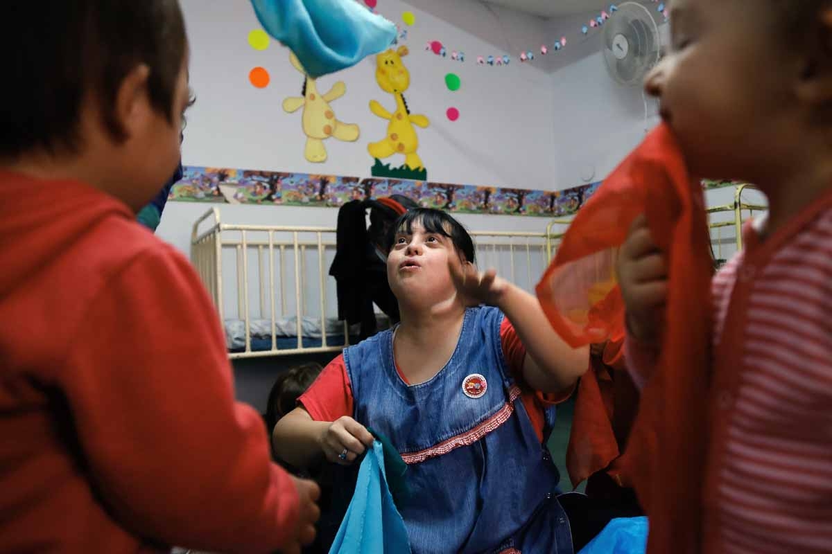 Noelia Garella (C), a kindergarten teacher born with Down Syndrome, plays with children at the Jeromito kindergarten in Cordoba, Argentina on September 29, 2016. Noelia Garella (C), a kindergarten teacher born with Down Syndrome, plays with children at the Jeromito kindergarten in Cordoba, Argentina on September 29, 2016.