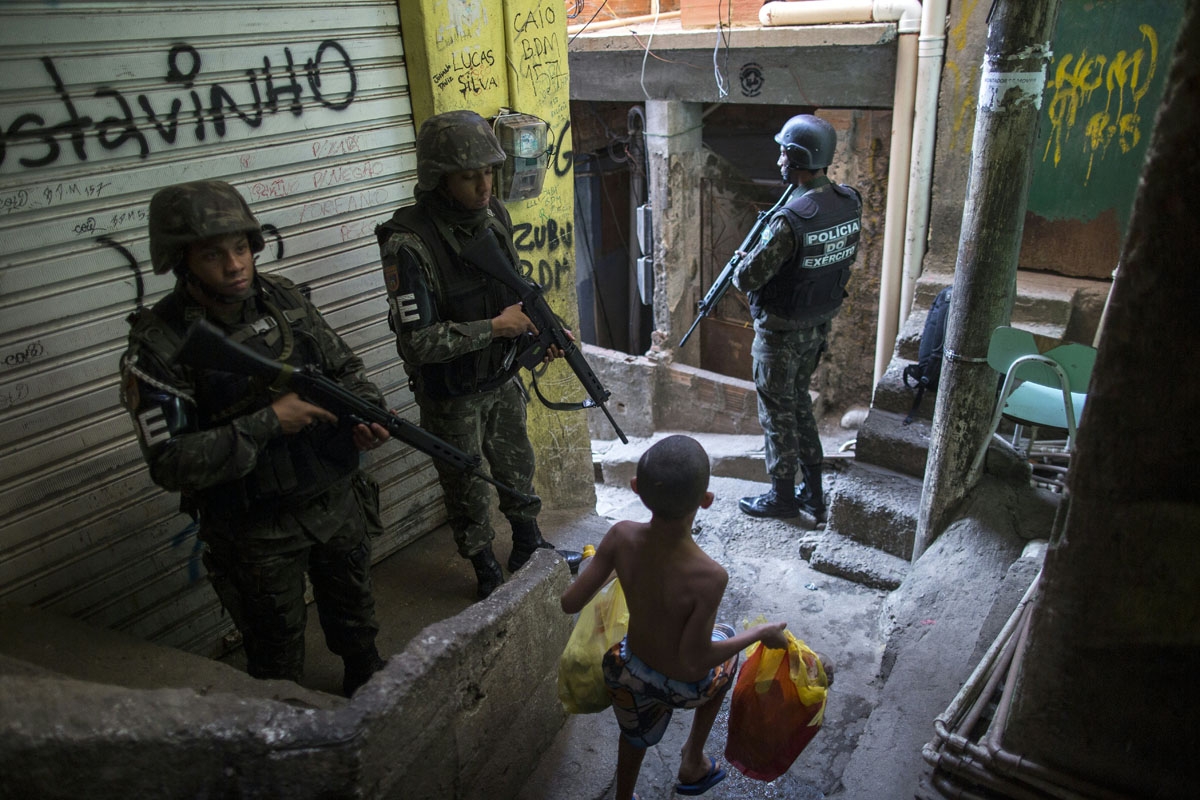 Employing urban combat tactics, Brazilian army military police personnel patrol along an alley in the Rocinha favela in Rio de Janeiro, Brazil on September 25, 2017. Security officials said the giant Rocinha favela in Rio de Janeiro was back under contro