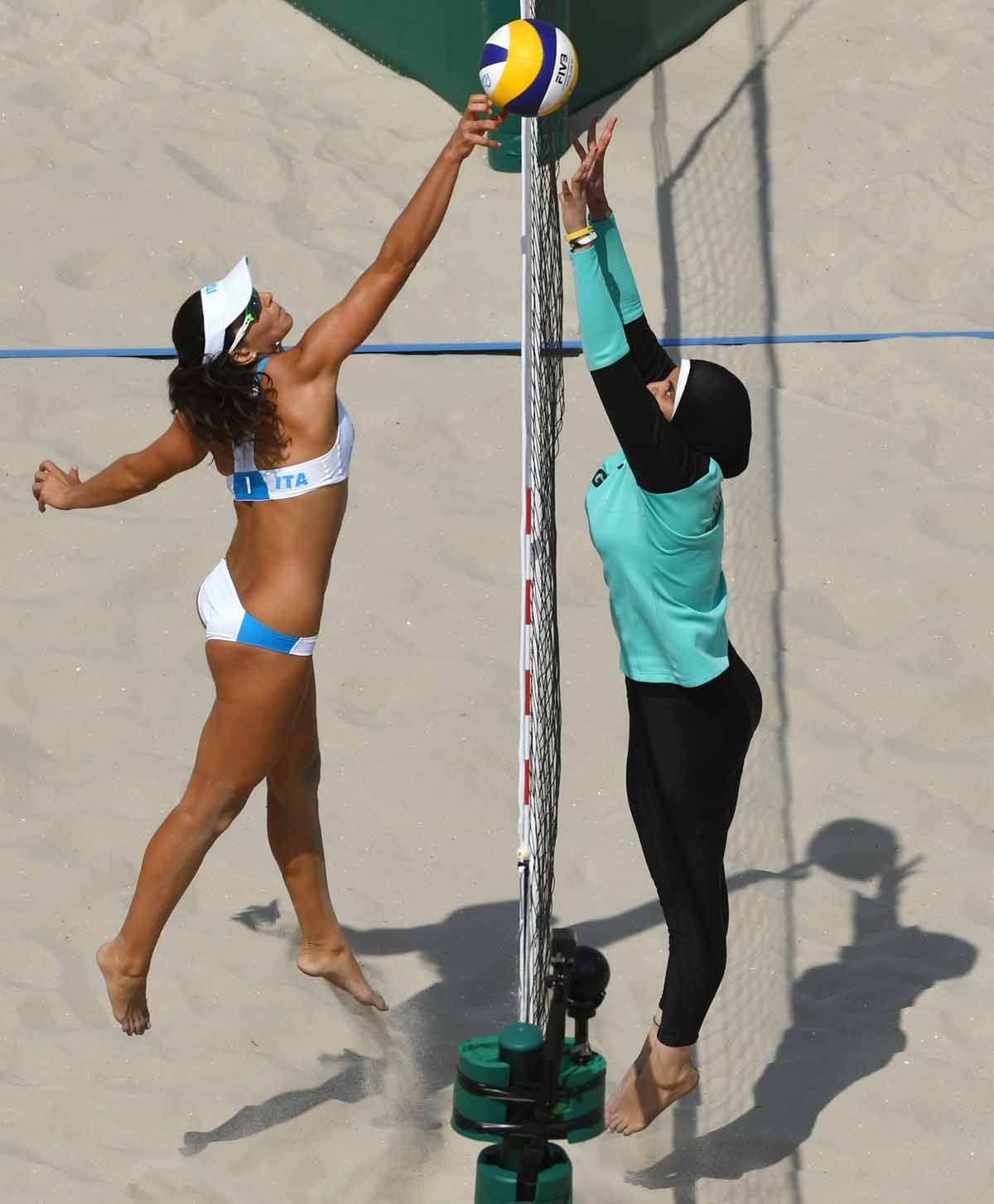 Italy's Marta Menegatti (L) jumps for the ball during the women's beach volleyball qualifying match between Italy and Egypt at the Beach Volley Arena in Rio de Janeiro on August 9, 2016, for the Rio 2016 Olympic Games. Italy's Marta Menegatti (L) jumps for the ball during the women's beach volleyball qualifying match between Italy and Egypt at the Beach Volley Arena in Rio de Janeiro on August 9, 2016, for the Rio 2016 Olympic Games.