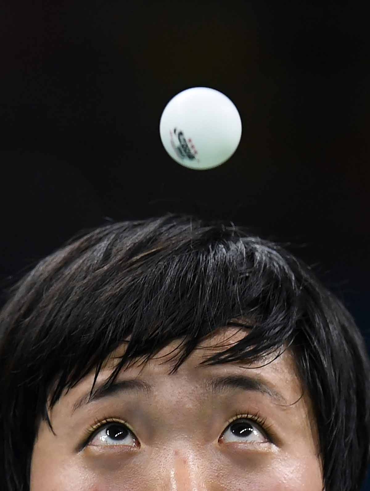 North Korea's Kim Song I eyes the ball as she serves against Japan's Ai Fukuhara in their women's singles bronze medal table tennis match at the Riocentro venue during the Rio 2016 Olympic Games in Rio de Janeiro on August 10, 2016. North Korea's Kim Song I eyes the ball as she serves against Japan's Ai Fukuhara in their women's singles bronze medal table tennis match at the Riocentro venue during the Rio 2016 Olympic Games in Rio de Janeiro on August 10, 2016.