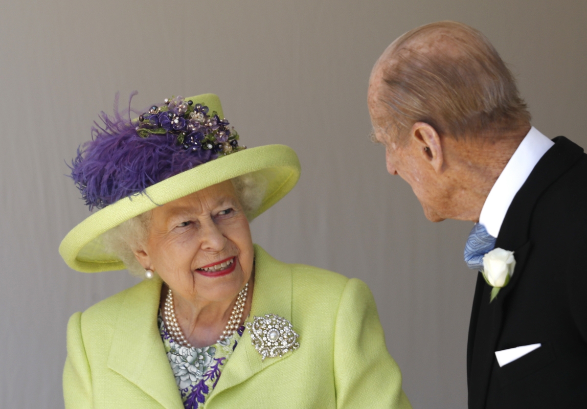 Britain's Queen Elizabeth II (L) talks with Britain's Prince Philip, Duke of Edinburgh (R) as they leave after attending the wedding ceremony of Britain's Prince Harry, Duke of Sussex and US actress Meghan Markle at St George's Chapel, Windsor Castle, in
