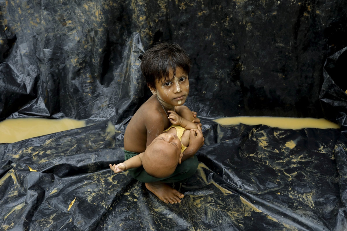 A Rohingya refugee from Myanmar's Rakhine state holds a baby after arriving at a refugee camp near the Bangladeshi town of Teknaf on September 5, 2017.