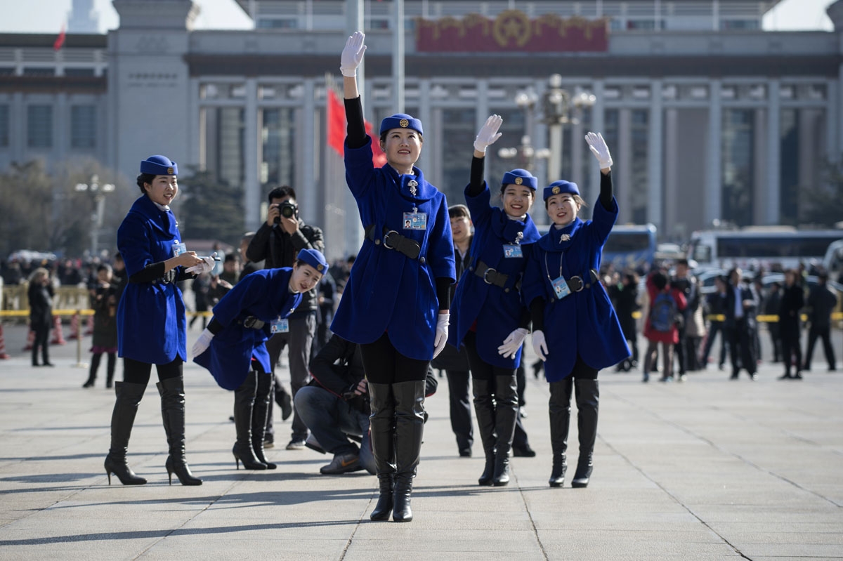 Hostesses pose for a picture in front of the Great Hall of the People during the opening of the National People's Congress in Beijing on March 5, 2017.