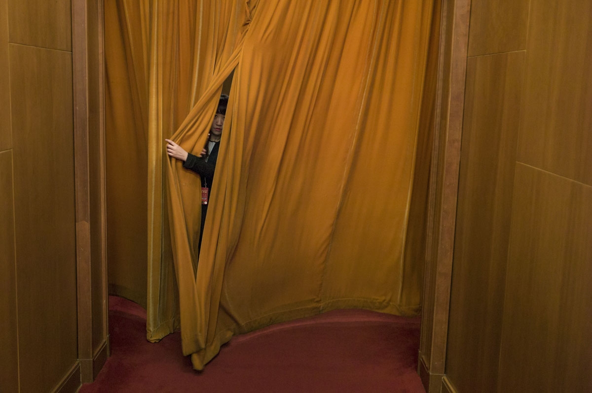 A delegate pulls the curtain to go to the second plenary session of the National People's Congress, China's legislature, at the Great Hall of the People in Beijing on March 8, 2017.