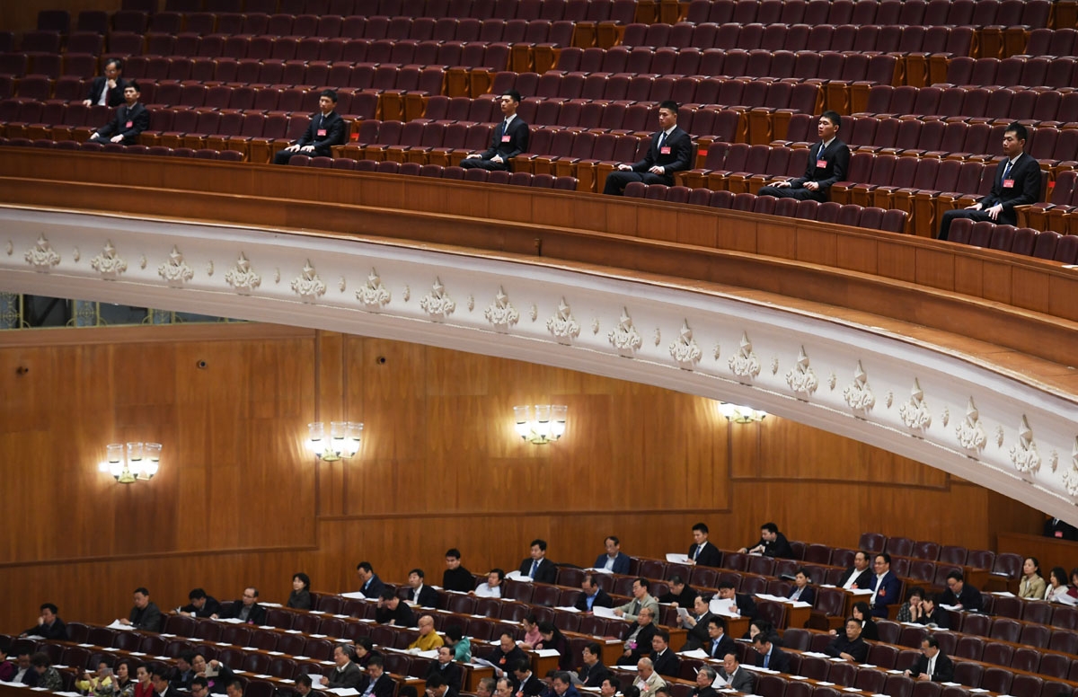 Security guards sit on a balcony above delegates during a plenary session of the Chinese People's Political Consultative Conference (CPPCC) at the Great Hall of the People in Beijing on March 10, 2017.