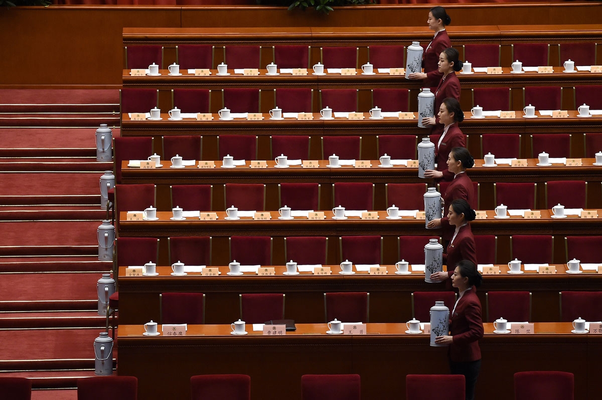 Chinese hostesses prepare for the closing session of the Chinese People's Political Consultative Conference (CPPCC) at the Great Hall of the People in Beijing on March 13, 2017.