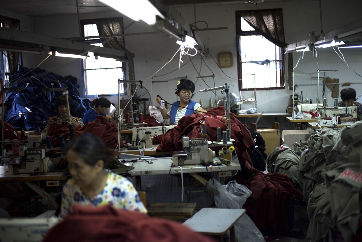 In this picture taken on September 8, 2016, workers prepare sew t-shirts in a factory in Zhujiajiao, on the outskirts of Shanghai.