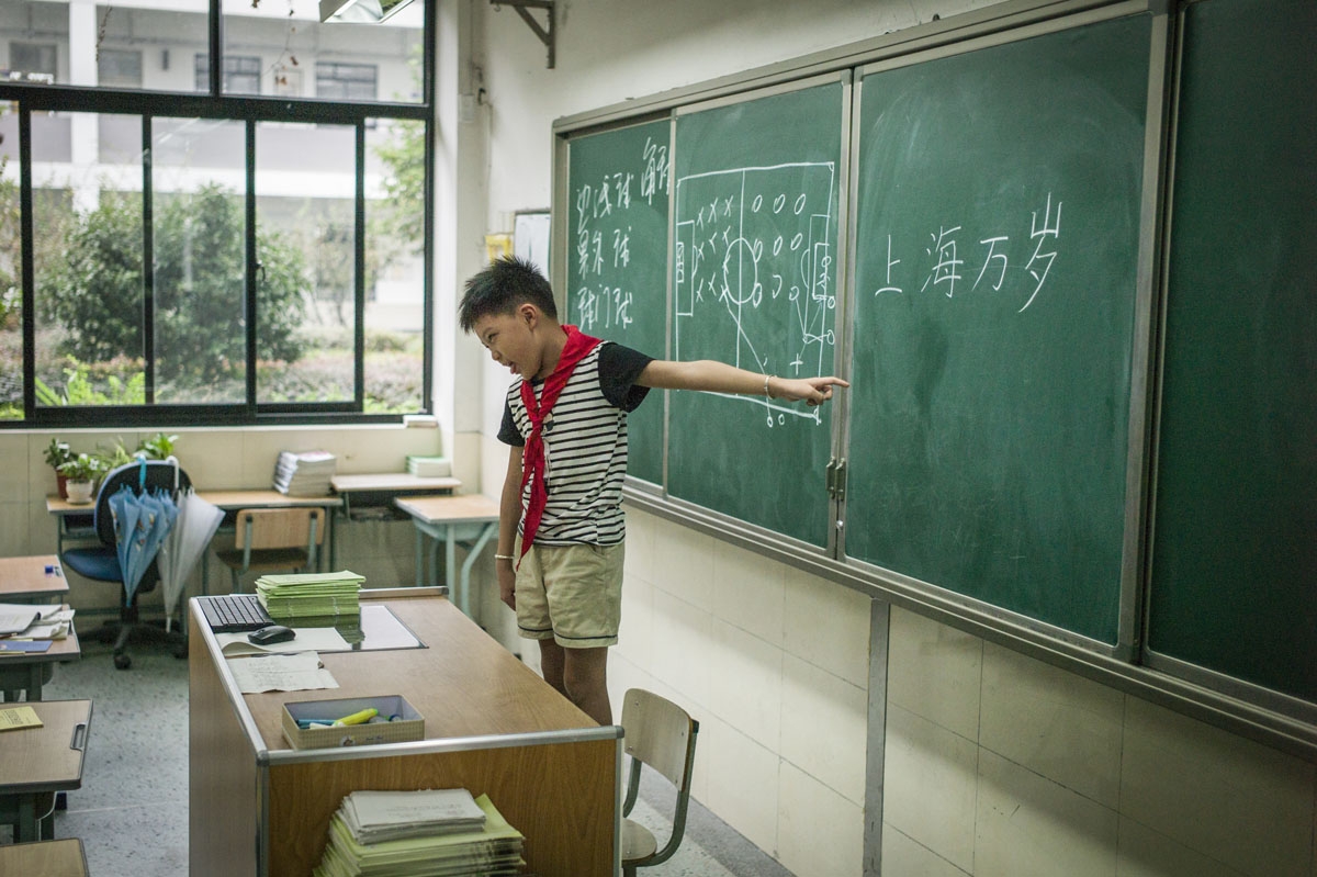 In this picture taken on September 8, 2016, a young boy points to Chinese characters written on the board at an elementary school in Zhujiajiao, on the outskirts of Shanghai.