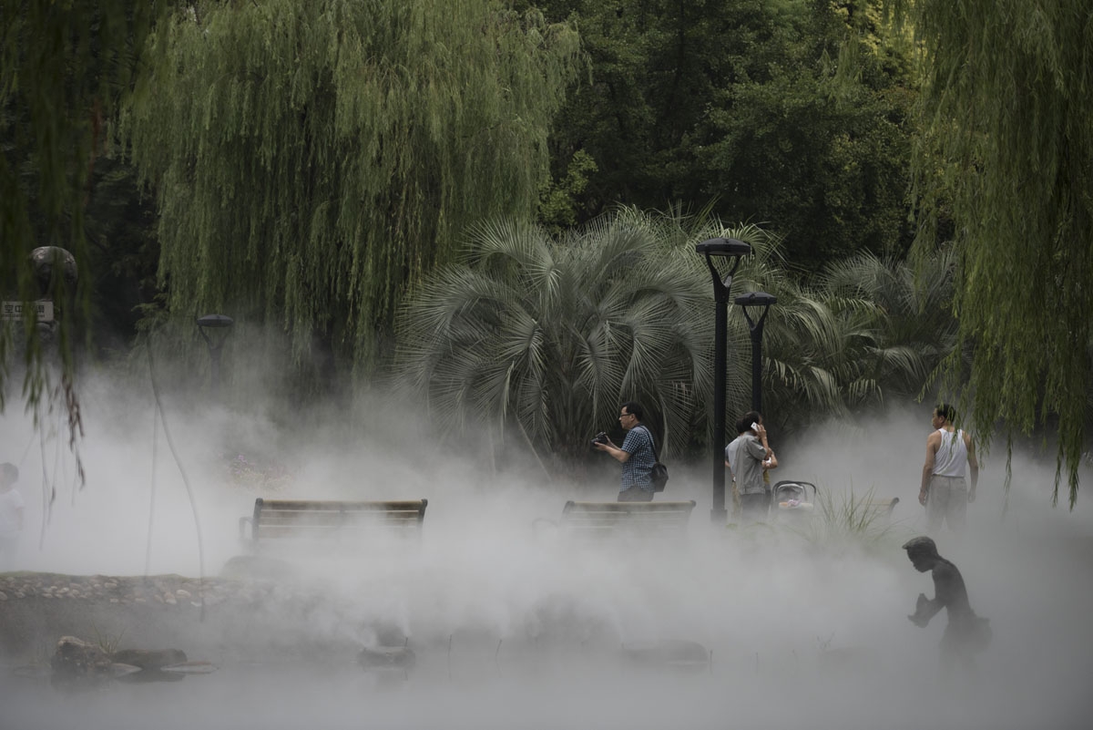 People take pictures of water spraying in Mengqinyuan park in Shanghai on September 11, 2016