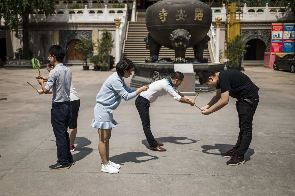 In this picture taken on September 12, 2016, people holding joss sticks pray at Jing'An temple ahead of the mid-autumn festival in Shanghai.