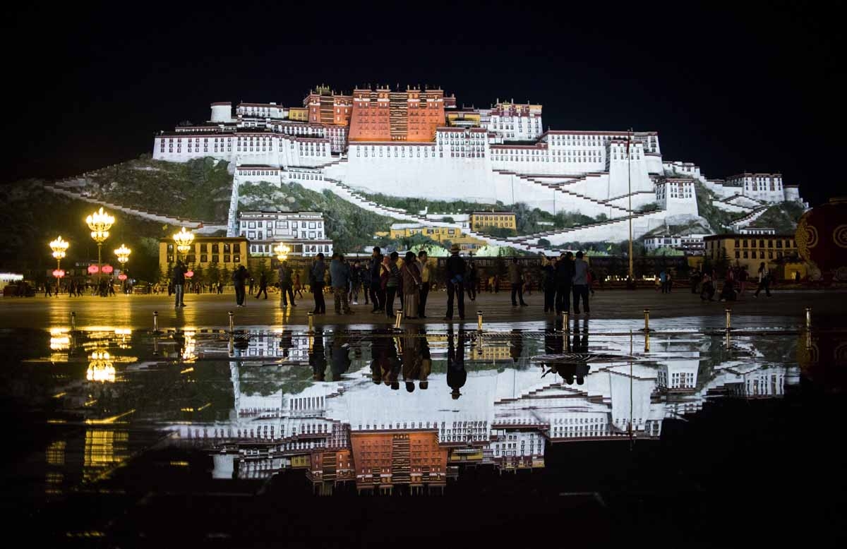 This picture taken on September 9, 2016 shows tourists in front of the iconic Potala Palace in the regional capital Lhasa, in China's Tibet Autonomous Region.