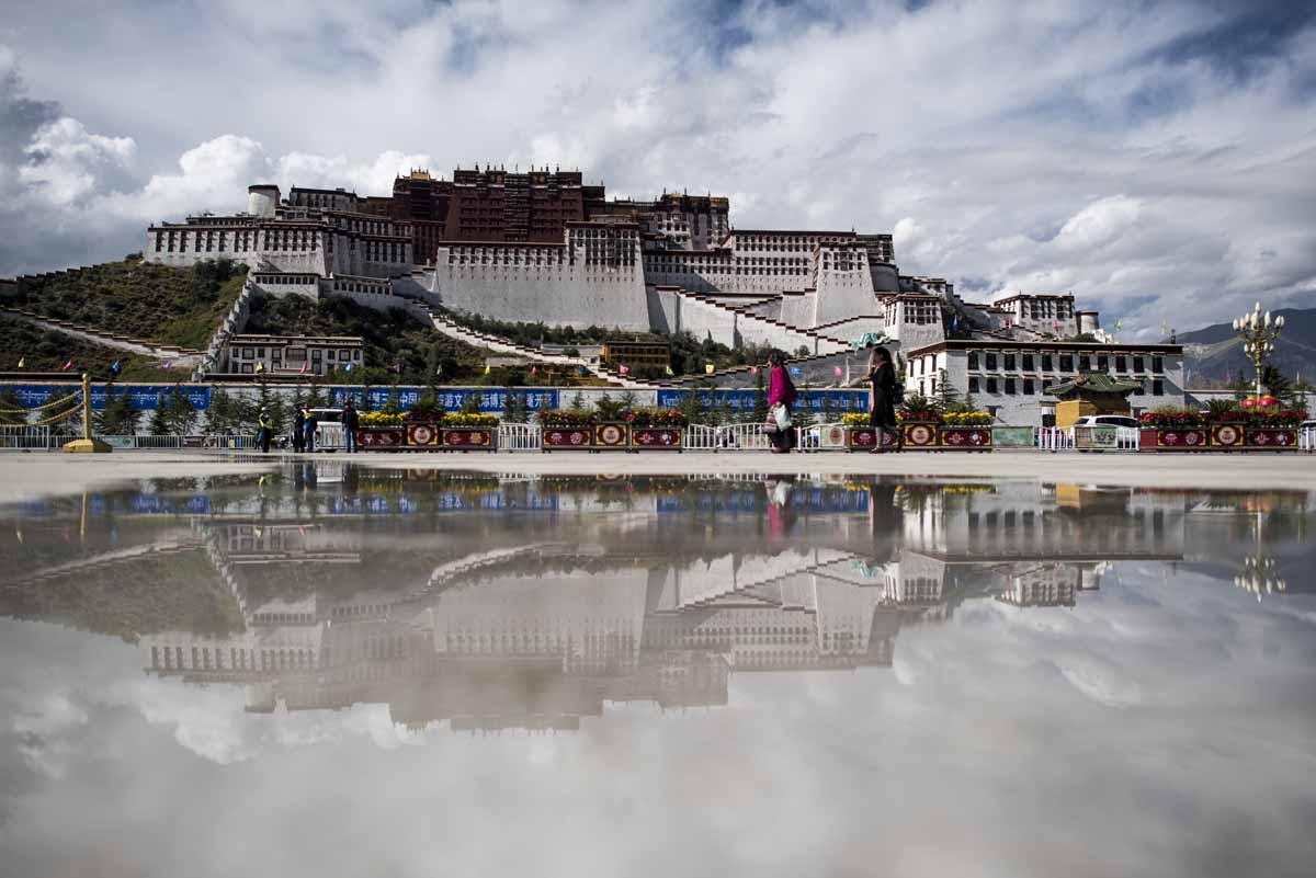 This picture taken on September 11, 2016 shows tourists in front of the iconic Potala Palace in the regional capital Lhasa, in China's Tibet Autonomous Region. 