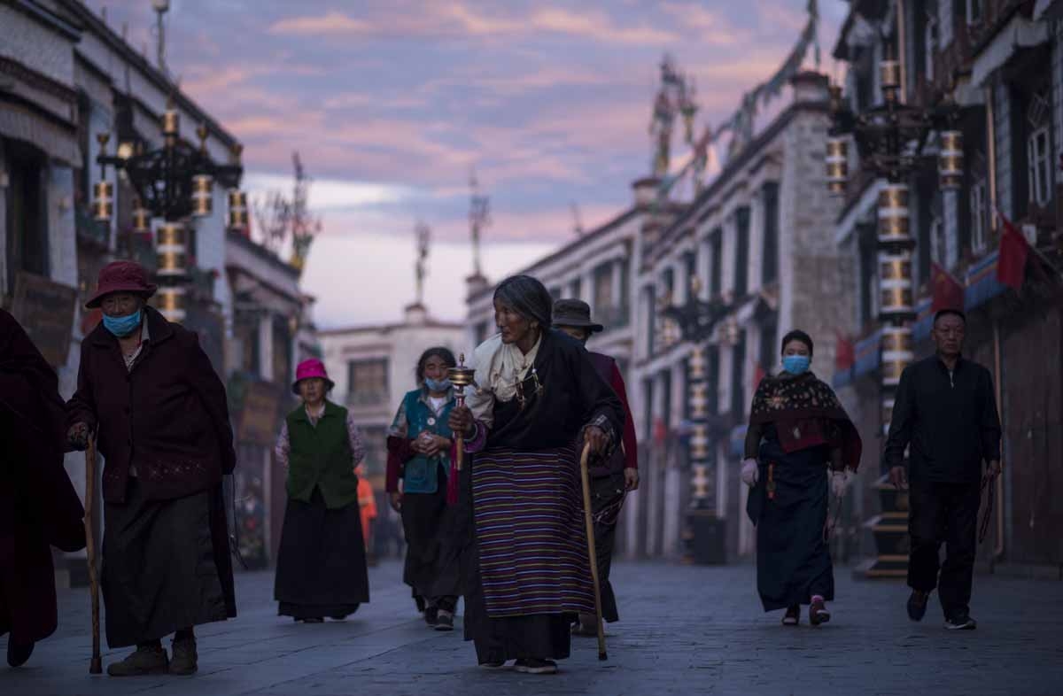 This picture taken on September 11, 2016 shows pilgrims walking and praying near the Jokhang Temple in the regional capital Lhasa, in China's Tibet Autonomous Region.