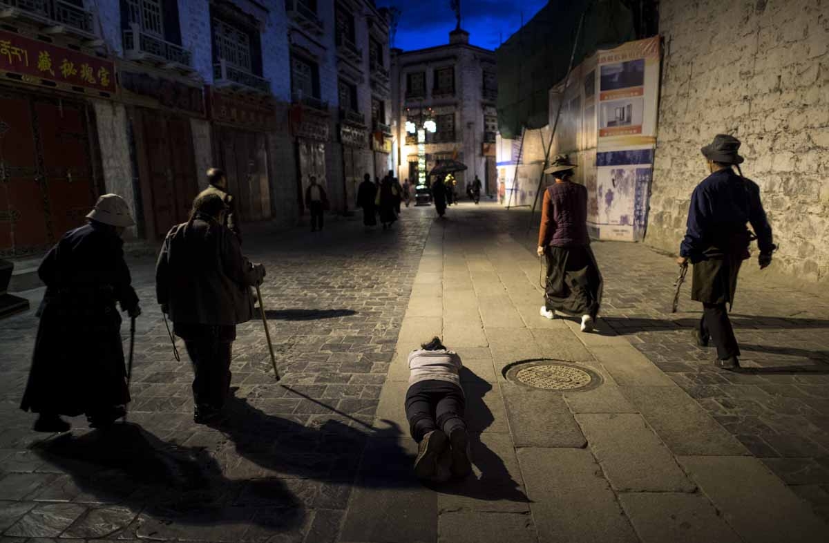 This picture taken on September 11, 2016 shows a pilgrim praying and prostrating outside the Jokhang Temple in the regional capital Lhasa, in China's Tibet Autonomous Region. 