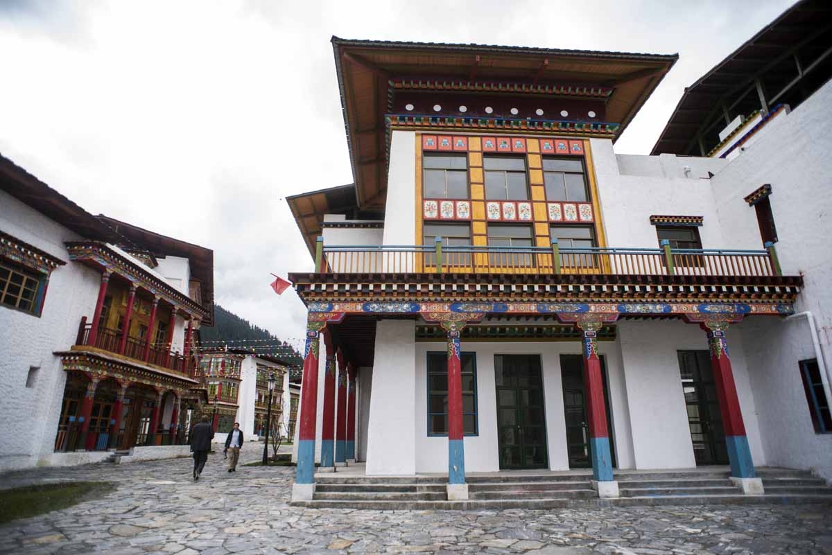 This picture taken on September 13, 2016 shows journalists walking past empty buildings in Lulang, near Nyingchi in China's Tibet Autonomous Region. 