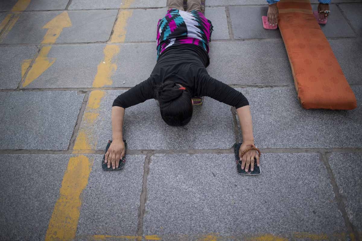 This picture taken on September 10, 2016 shows a pilgrim praying and prostrating outside the Jokhang Temple in the regional capital Lhasa, in China's Tibet Autonomous Region.