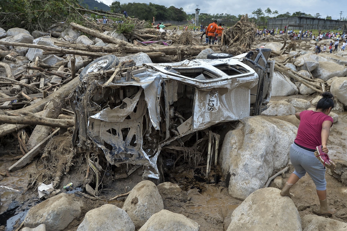 A woman walks amidst the rubble left by mudslides following heavy rains in Mocoa, Putumayo department, southern Colombia on April 2, 2017.