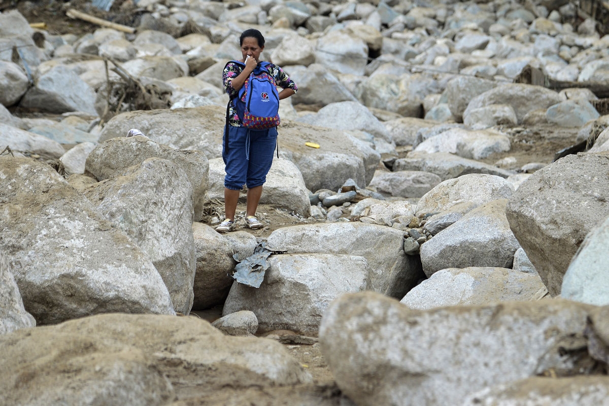 A woman cries amidst the rubble left by mudslides following heavy rains in Mocoa, Putumayo department, southern Colombia on April 2, 2017.