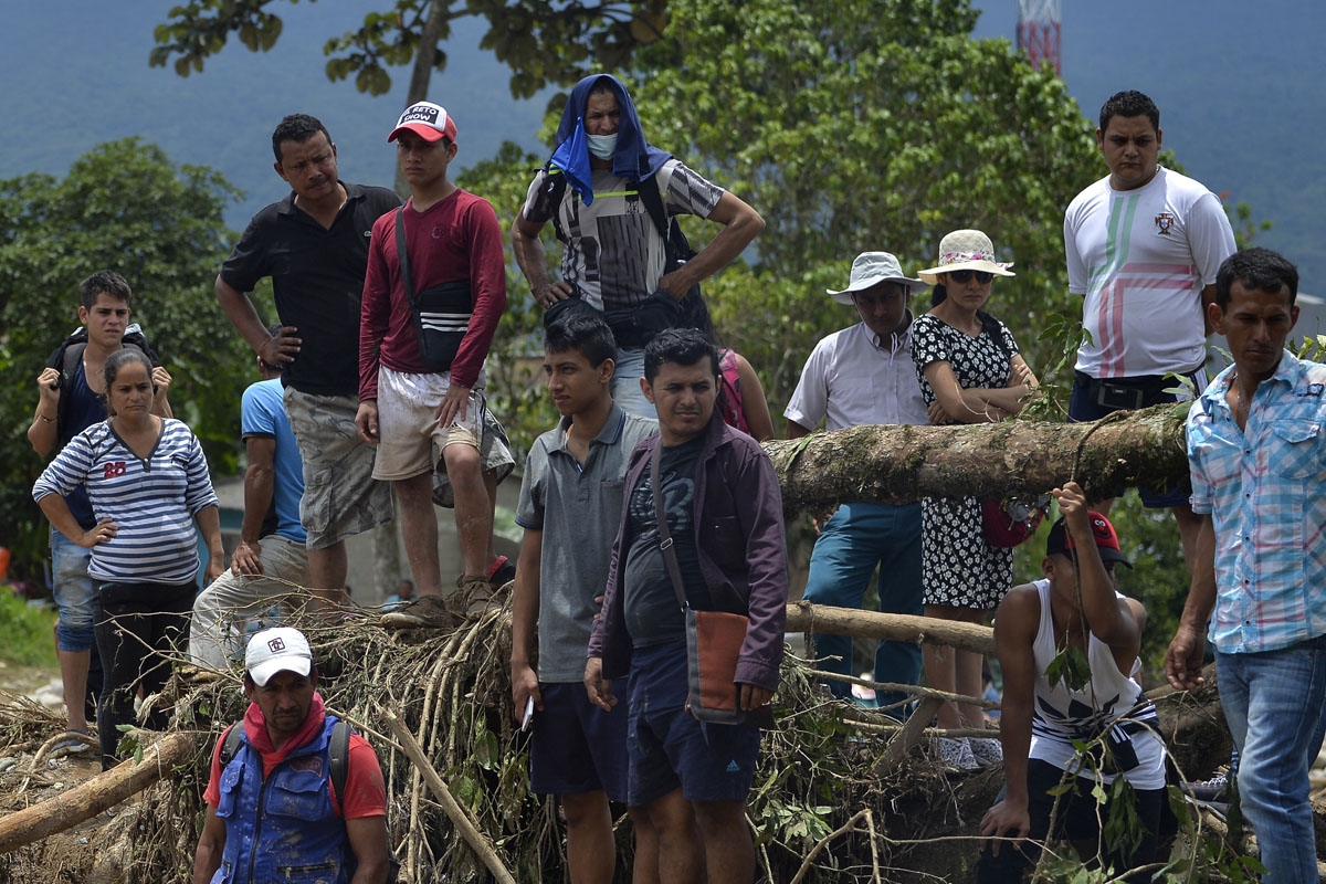 People look on as rescuers search for bodies under the rubble left by mudslides following heavy rains in Mocoa, Putumayo department, southern Colombia on April 2, 2017.