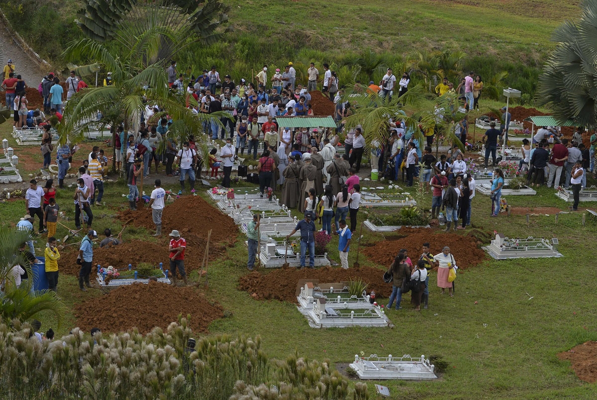People attend the mass burial of the victims of a mudslide caused by heavy rains, at the cemetery in Mocoa, Putumayo department, Colombia on April 3, 2017.