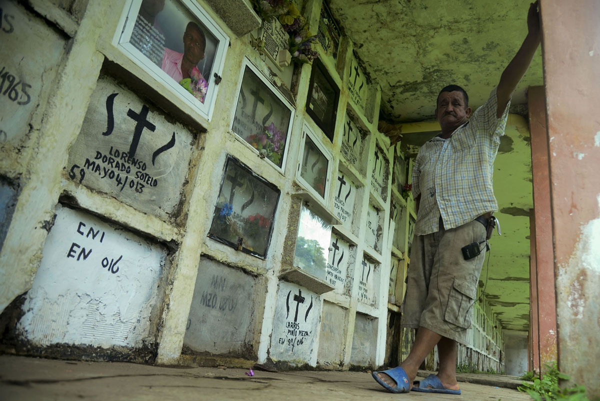 Colombian gravedigger Ebelio Cortez stands next to unidentified tombs of migrants at the Nuestra Senora del Carmen cemetery in the Turbo municipality, Antioquia department, Colombia, on June 15, 2016