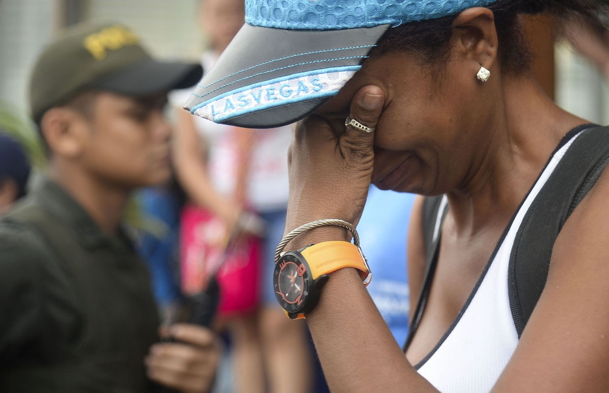 A Cuban migrant cries before boarding a vessel to Capurgana, in the Caribbean Gulf of Uraba in northwestern Colombia, to illegally cross to Panama through the jungle, on August 6, 2016