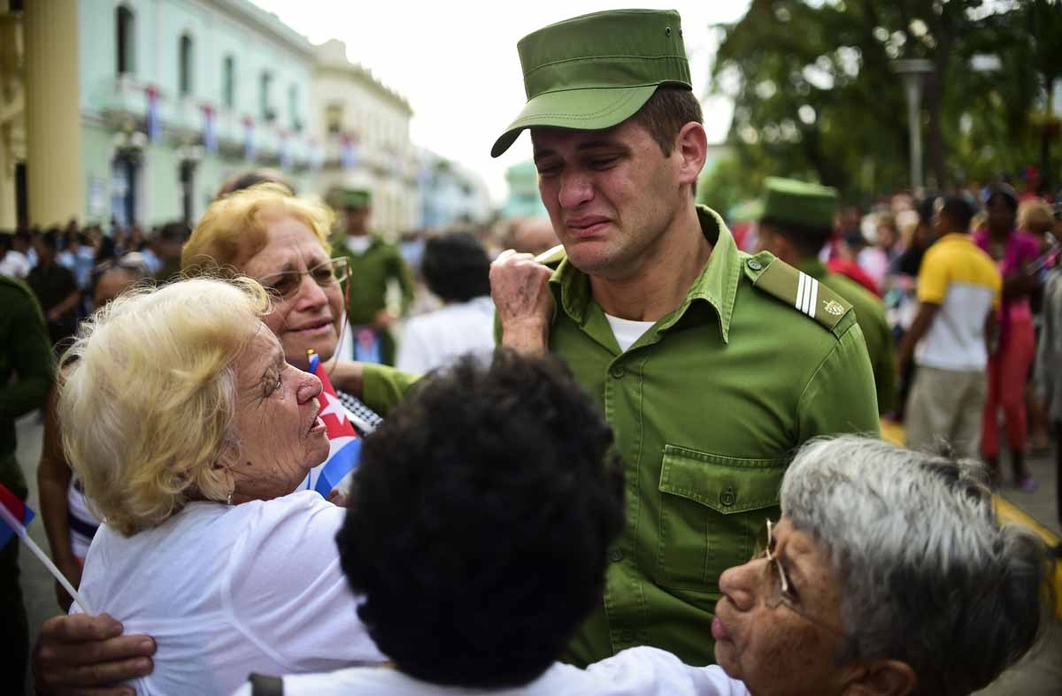 A soldier is comforted after the urn with the ashes of Cuban leader Fidel Castro was driven through Santa Clara on December 1, 2016 during its four-day journey across the island for the burial in Santiago de Cuba. A soldier is comforted after the urn with the ashes of Cuban leader Fidel Castro was driven through Santa Clara on December 1, 2016 during its four-day journey across the island for the burial in Santiago de Cuba.