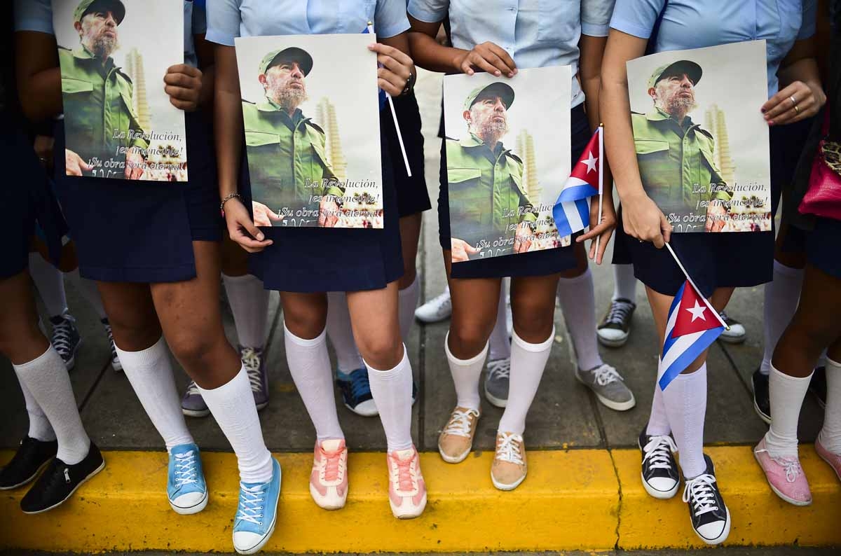 High school students wait the urn with the ashes of Cuban leader Fidel Castro was driven through Santa Clara on December 1, 2016 during its four-day journey across the island for the burial in Santiago de Cuba. High school students wait the urn with the ashes of Cuban leader Fidel Castro was driven through Santa Clara on December 1, 2016 during its four-day journey across the island for the burial in Santiago de Cuba.