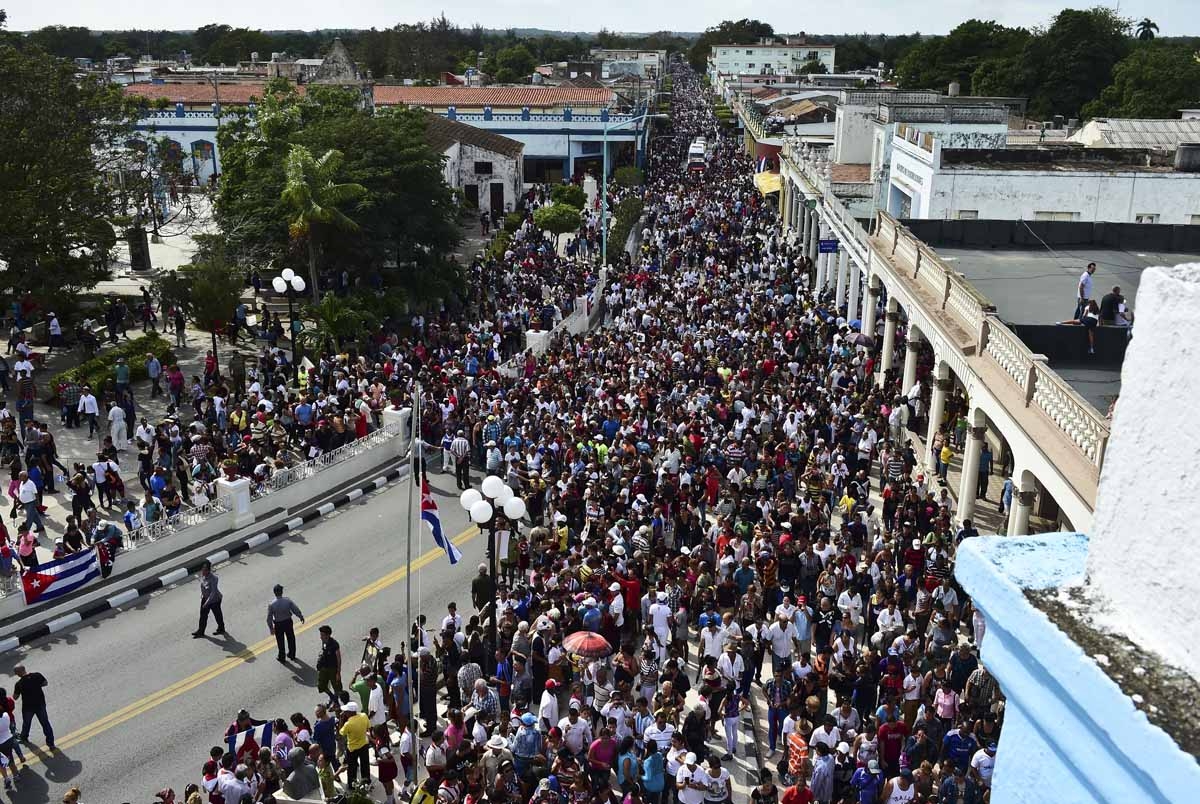 People follow the convoy transporting the urn with the ashes of Cuban leader Fidel Castro through the streets of Las Tunas, Cuba, on December 2, 2016 during its four-day journey across the island for the burial in Santiago de Cuba. People follow the convoy transporting the urn with the ashes of Cuban leader Fidel Castro through the streets of Las Tunas, Cuba, on December 2, 2016 during its four-day journey across the island for the burial in Santiago de Cuba.
