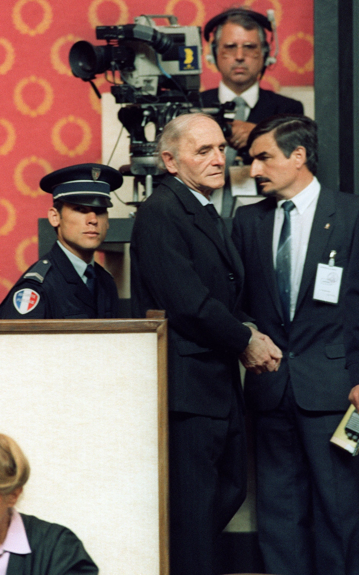 Former SS officer Klaus Barbie, the Butcher of Lyons, in handcuffs, arrives at the courthouse, in Lyons, 11 May 1987 o
