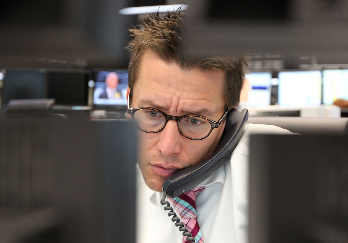 A stock broker works behind computer monitors at the stock exchange in Frankfurt/Main, central Germany, on August 8, 2011.