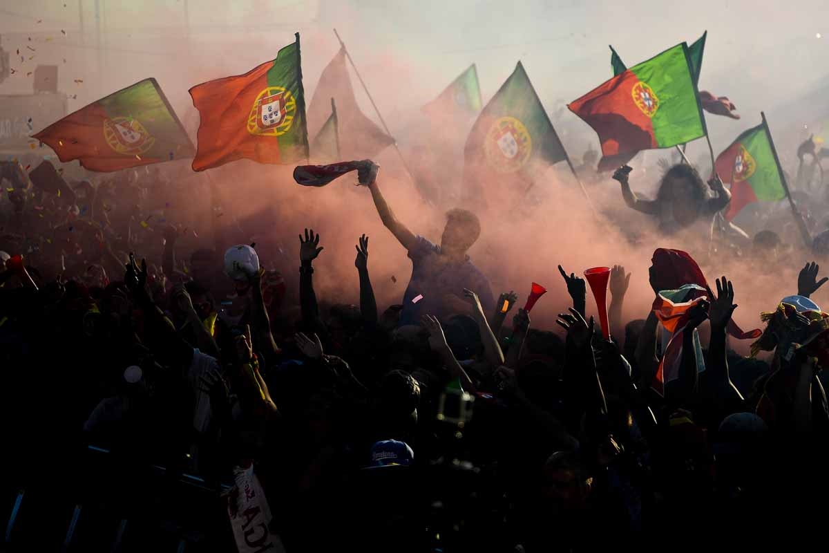Portugal's national football team supporters wave flags at Terreiro do Paco square in Lisbon on July 10, 2016 as they watch on a giant screen the Euro 2016 final football match Portugal vs France played in Paris. / AFP PHOTO / PATRICIA DE MELO MOREIRA Portugal's national football team supporters wave flags at Terreiro do Paco square in Lisbon on July 10, 2016 as they watch on a giant screen the Euro 2016 final football match Portugal vs France played in Paris. / AFP PHOTO / PATRICIA DE MELO MOREIRA