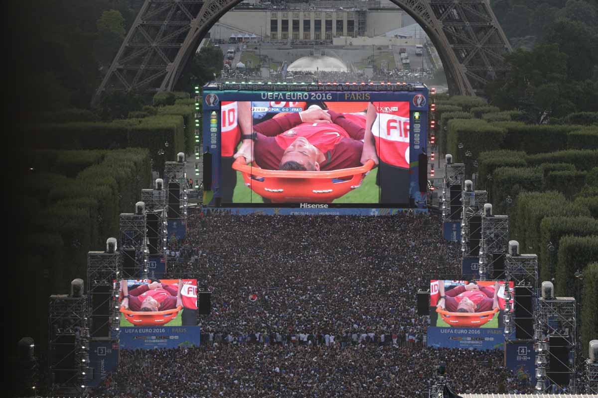 People watch on a giant screen the Euro 2016 football tournament final match between Portugal and France, while Portuguese forward Cristiano Ronaldo is evacuated on a stretcher after being injured, on July 10, 2016 at the fan zone of the Champs de Mars ne People watch on a giant screen the Euro 2016 football tournament final match between Portugal and France, while Portuguese forward Cristiano Ronaldo is evacuated on a stretcher after being injured, on July 10, 2016 at the fan zone of the Champs de Mars ne