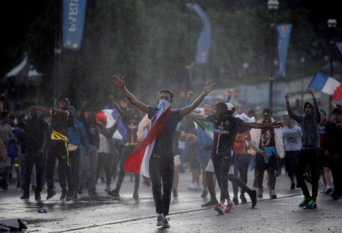 Men clash with French riot policemen after attempting to enter the fan zone of the Champs de Mars next to the Eiffel tower in Paris on July 10, 2016 during the Euro 2016 football tournament final match between Portugal and France. / AFP PHOTO / ALAIN JOCA Men clash with French riot policemen after attempting to enter the fan zone of the Champs de Mars next to the Eiffel tower in Paris on July 10, 2016 during the Euro 2016 football tournament final match between Portugal and France. / AFP PHOTO / ALAIN JOCA