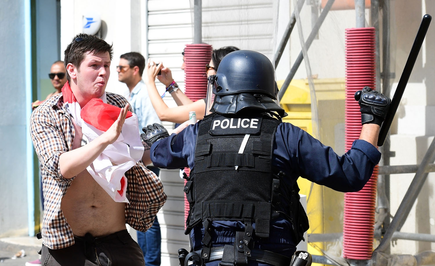 An England fan (L) clashes with police personnel in the city of Marseille, southern France, on June 11, 2016