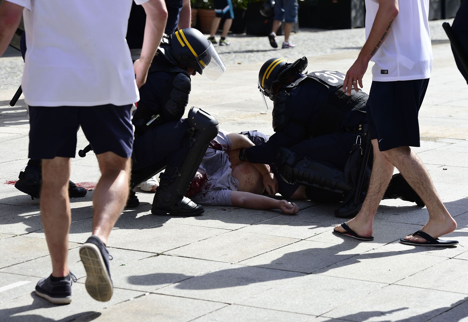 Police personnel attend to an injured fan following clashes between England fans and police personnel in the city of Marseille, southern France, on June 11, 2016