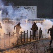 People run as anti riot police spread tear gas in Bobigny, northern Paris, on February 16, 2017 during a demonstration to demand justice for Theo, a 22-year-old youth worker who required surgery after his arrest last week in the gritty suburb of Aulnay-s