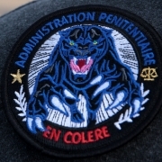 A picture taken on April 10, 2017 shows a badge reading prison administration angry during a blockading of the Fleury-Merogis prison by prison supervisors called by several unions following an attack against six prison wardens.
