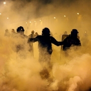 Gendarmes stand among tear gas during clashes with protesters outside the Fleury-Merogis prison, near Paris, on April 10, 2017, during a demonstration by prison guards after six of their colleagues were injured by inmates.