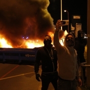 A protester uses his phone near a burning barricade outside the Fleury-Merogis prison, near Paris, on April 10, 2017, during a demonstration by prison guards after six of their colleagues were injured by inmates.
