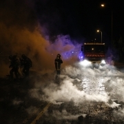 Firemen walks in a smoldering fire outside the Fleury-Merogis prison, near Paris, on April 10, 2017, during a demonstration by prison guards after six of their colleagues were injured by inmates.