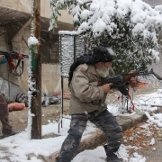 Rebel fighters hold their weapons as they stand amidst snow during clashes with Syrian pro-government forces in the Salaheddin neighbourhood of Syria's northern city of Aleppo on December 11, 2013.