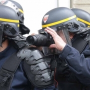 A French anti-riot policeman takes pictures during a demonstration for a social first round of the French presidential election on April 22, 2017 on the place de la Republique in Paris.
